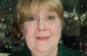 Janet looking festive in front of a Christmas tree