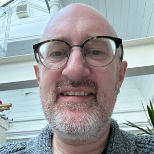 Dick wearing glasses and smiling