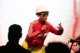 A construction worker in shades rapping