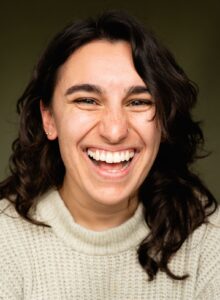 Maryam laughing with half her hair falling down the left of her face