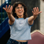 A woman with her arms in front as if beckoning in a dance