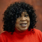 Cheryl in a red jumper smiling to camera