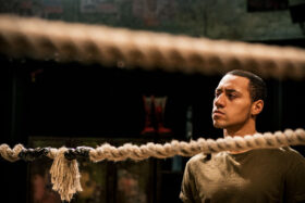A man looking pensive in a wrestling ring